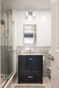 Compact NYC bathroom with glass shower and modern vanity.