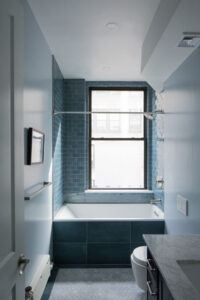 NYC loft bathroom with custom blue tile work and natural light