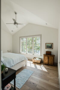 Bedroom with vaulted ceiling and lake view windows, designed by Rauch Architecture.