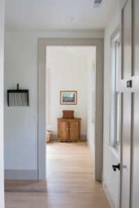 Hallway view towards an antique cabinet in a Rauch Architecture home.